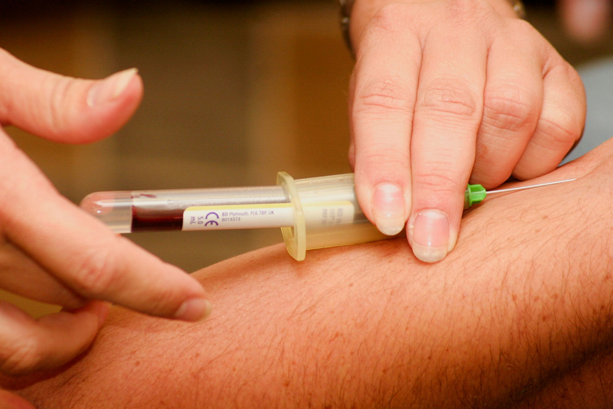 An image of a needle being inserted into a bottle of medication